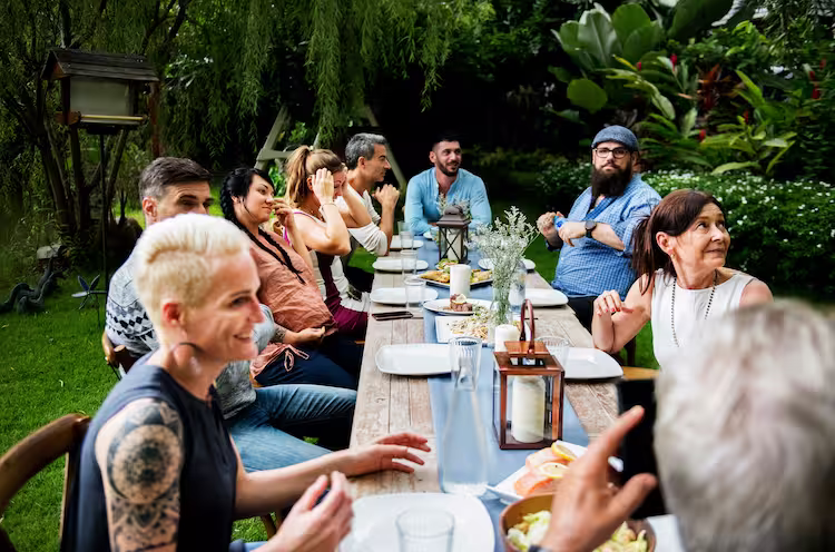 A group of people gathered around a table ready for an outdoor meal.